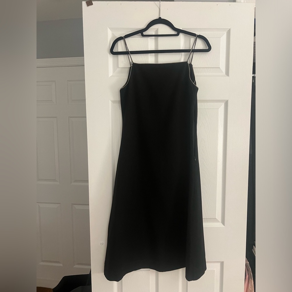 Black midi dress jumper has zipper detailing as the straps